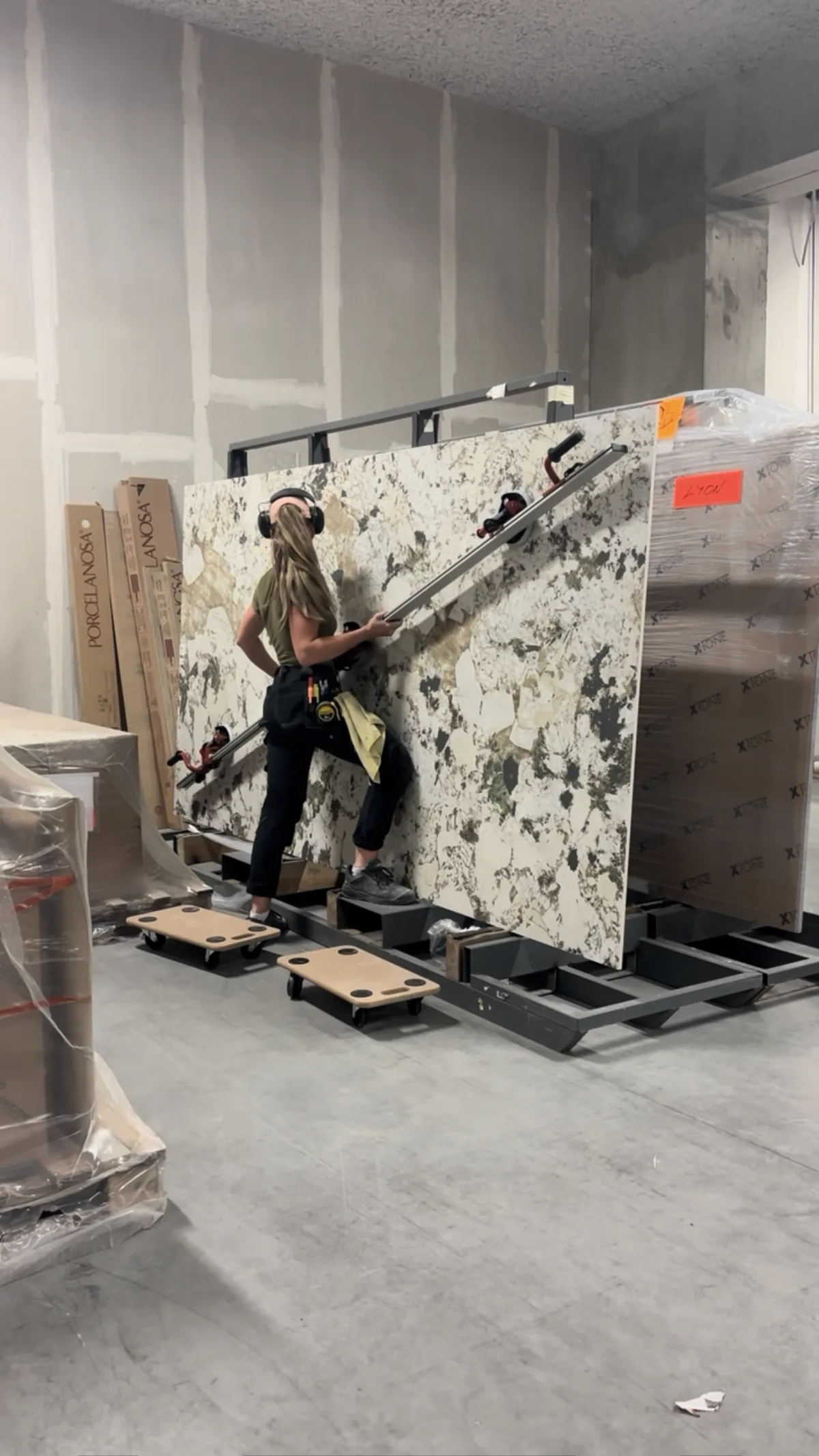 La carreleuse de MD Carrelage manipule une plaque de grand format en atelier avant la pose.