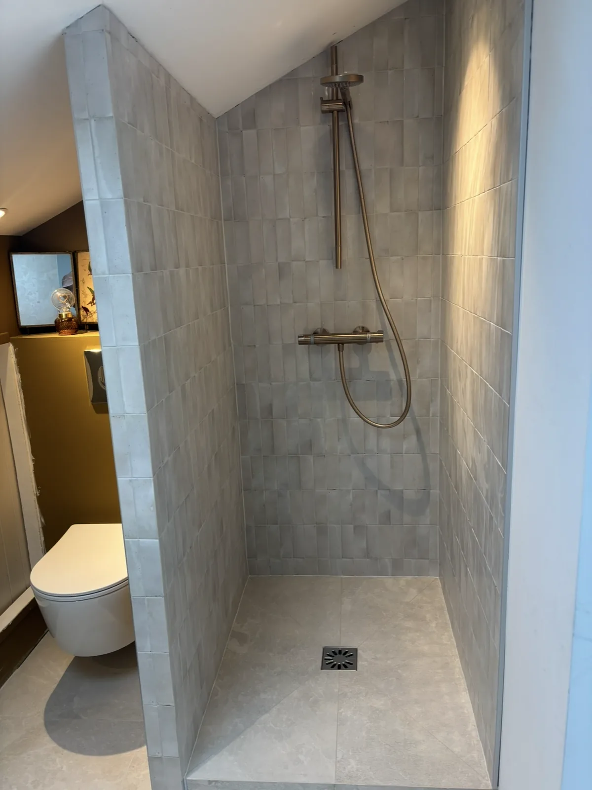 Douche à l'italienne avec faïence murale verticale effet zellige gris.